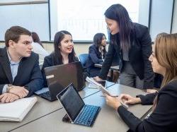 Photo of a teacher talking to a group of students.