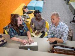 Nursing students in the School of Nursing lobby discussing an assignment.