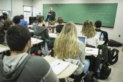 Photo of a classroom scene with Mark Clatterbuck teaching in front of a chalkboard.