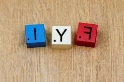 Image of three wooden blocks on a wood table. Each block as a letter as used in a Scrabble game: F Y I.